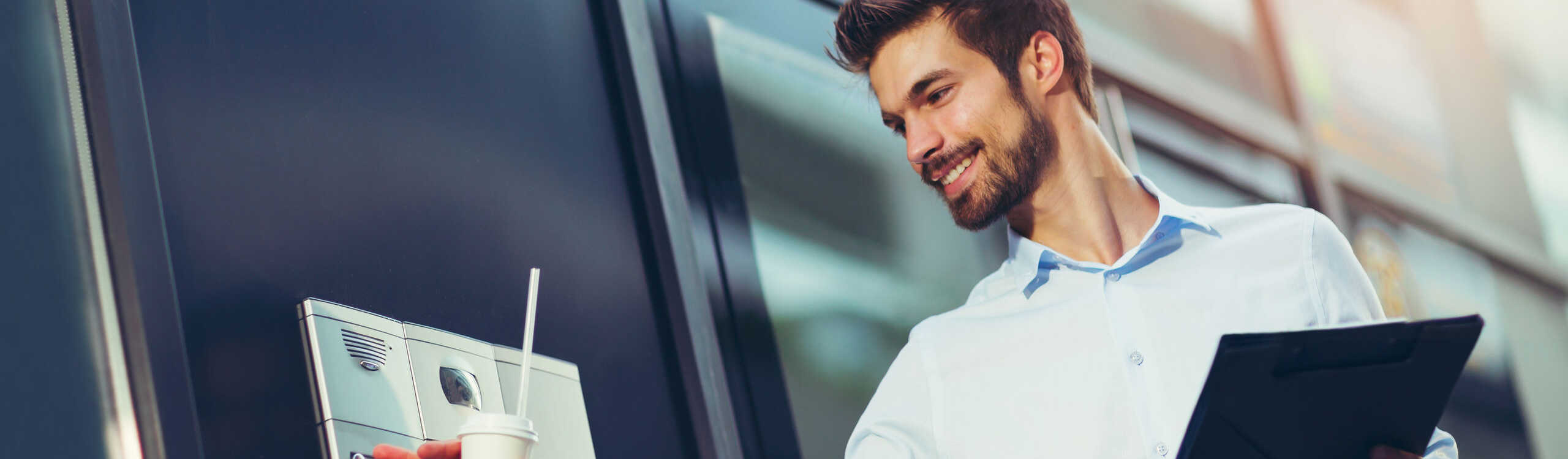 Portrait of a young happy businessman who is ringing the bell at a door intercom