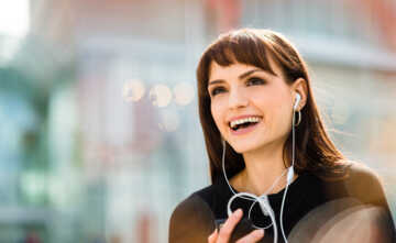 Young woman calling phone with hands free and laughing