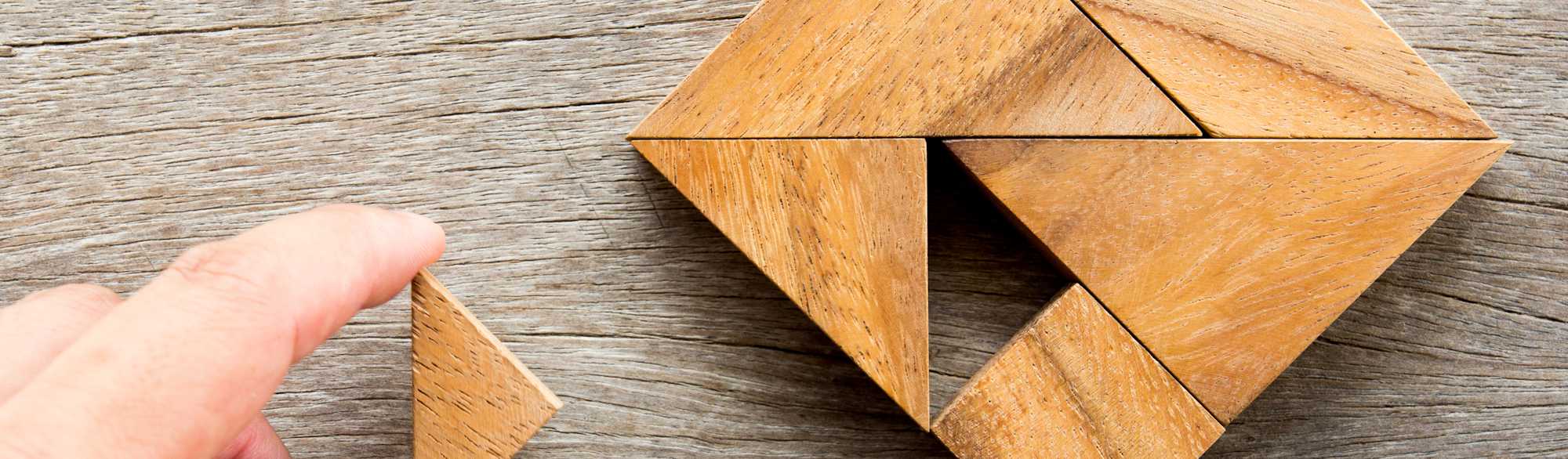 Man held piece of tangram puzzle to fulfill the heart shape