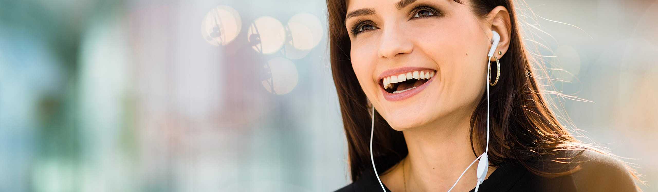 Frau telefoniert lachend über ein Headset