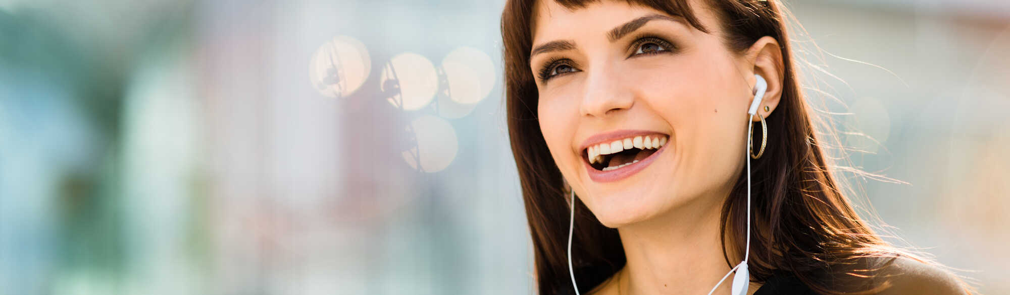 Young woman calling phone with hands free and laughing