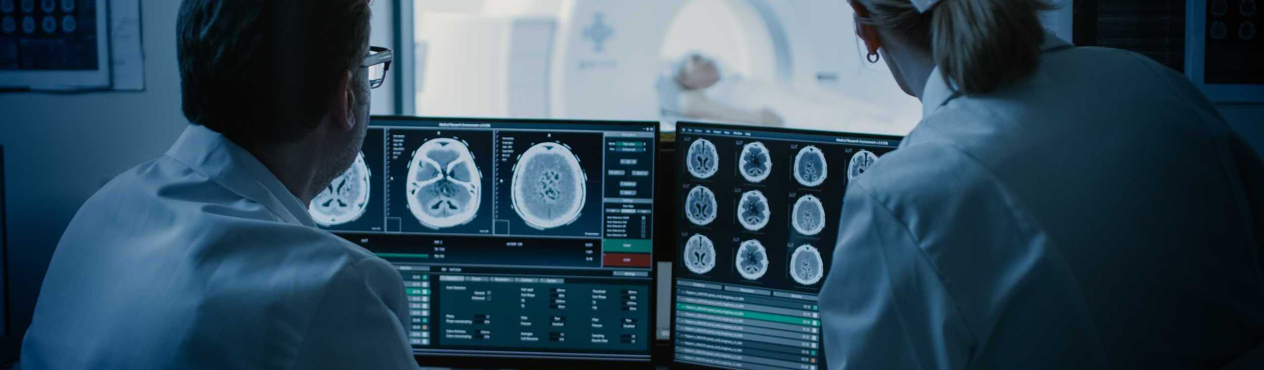 Patient beim CT-Scan, Ärzte begutachten CT-Bilder