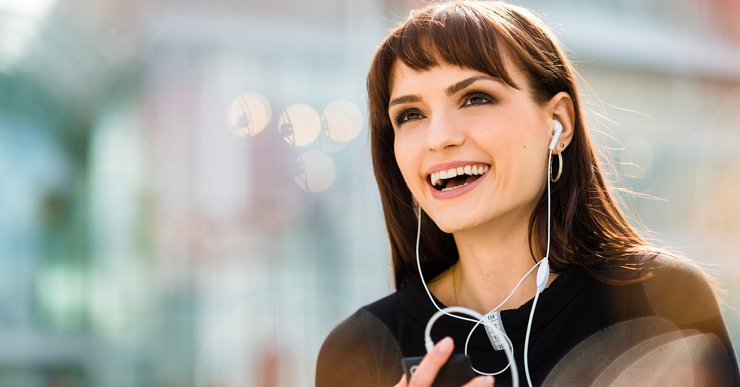 Young woman calling phone with hands free and laughing